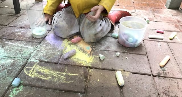 Sohn 2.0 sitzt im Regen und malt mit Kreide. | Mehr Infos auf Mamaskind.de