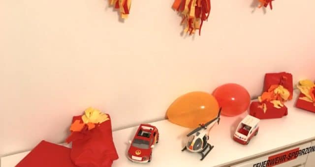 Deko zur Feuerwehr-Party: Tassel-Girlande, Luftballons, Geschenke in Seidenpapier und Absperrband. | Mehr Infos zu unserer Deko, Spielen und dem Essen zur Feuerwehrparty auf Mamaskind.de