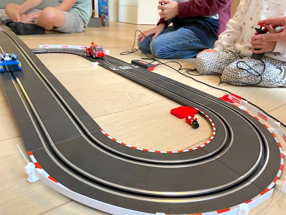 Drei Kinder wollen mit der Carrera-Bahn Rennen fahren. Mit Geduld - mamaskind.de